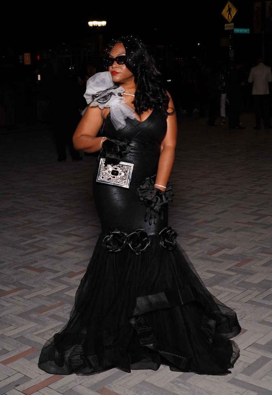 Jessica in a black mermaid gown with a jeweled clutch
