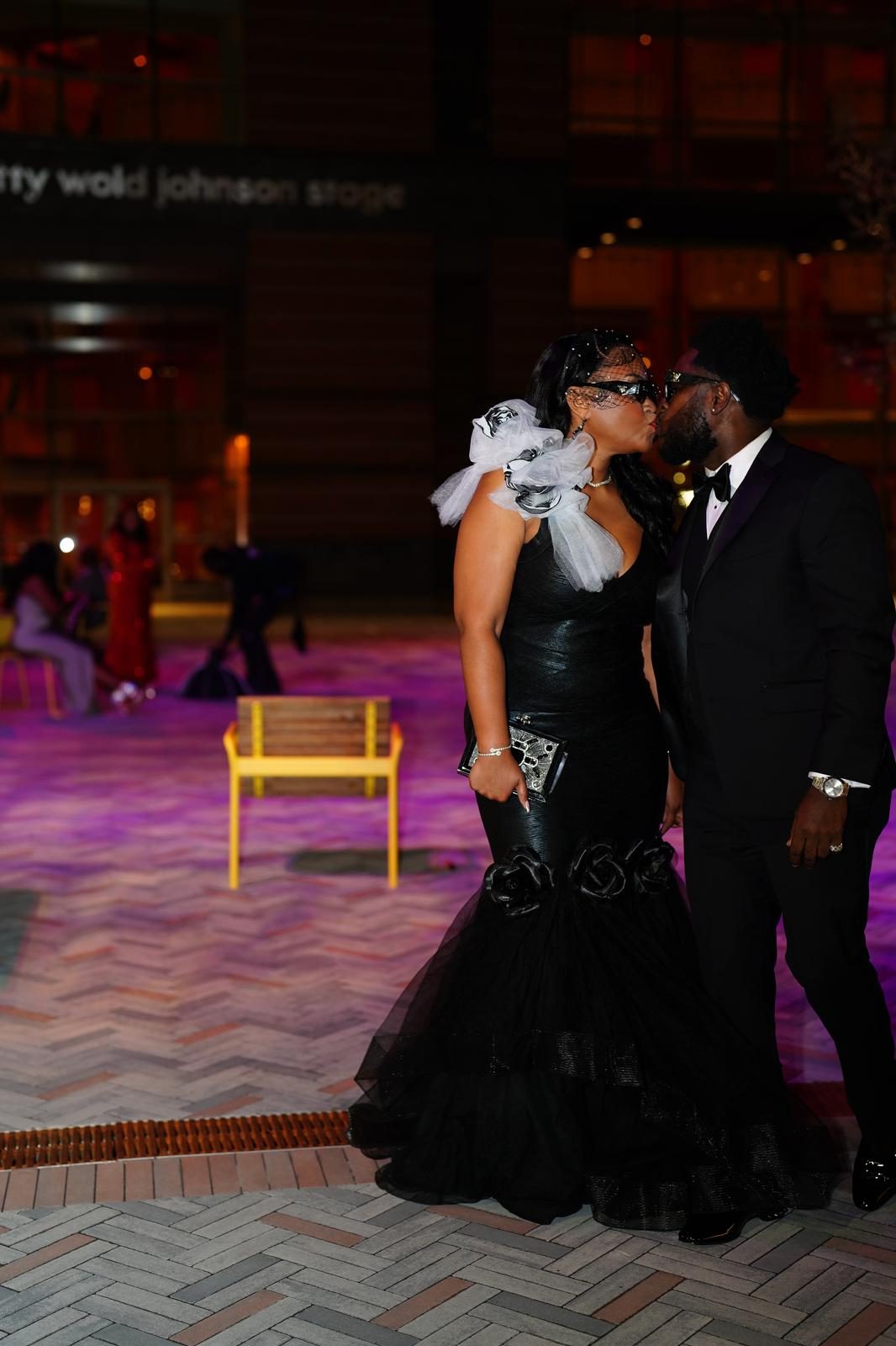 Eugene and Jessica sharing a kiss at night in black tie attire
