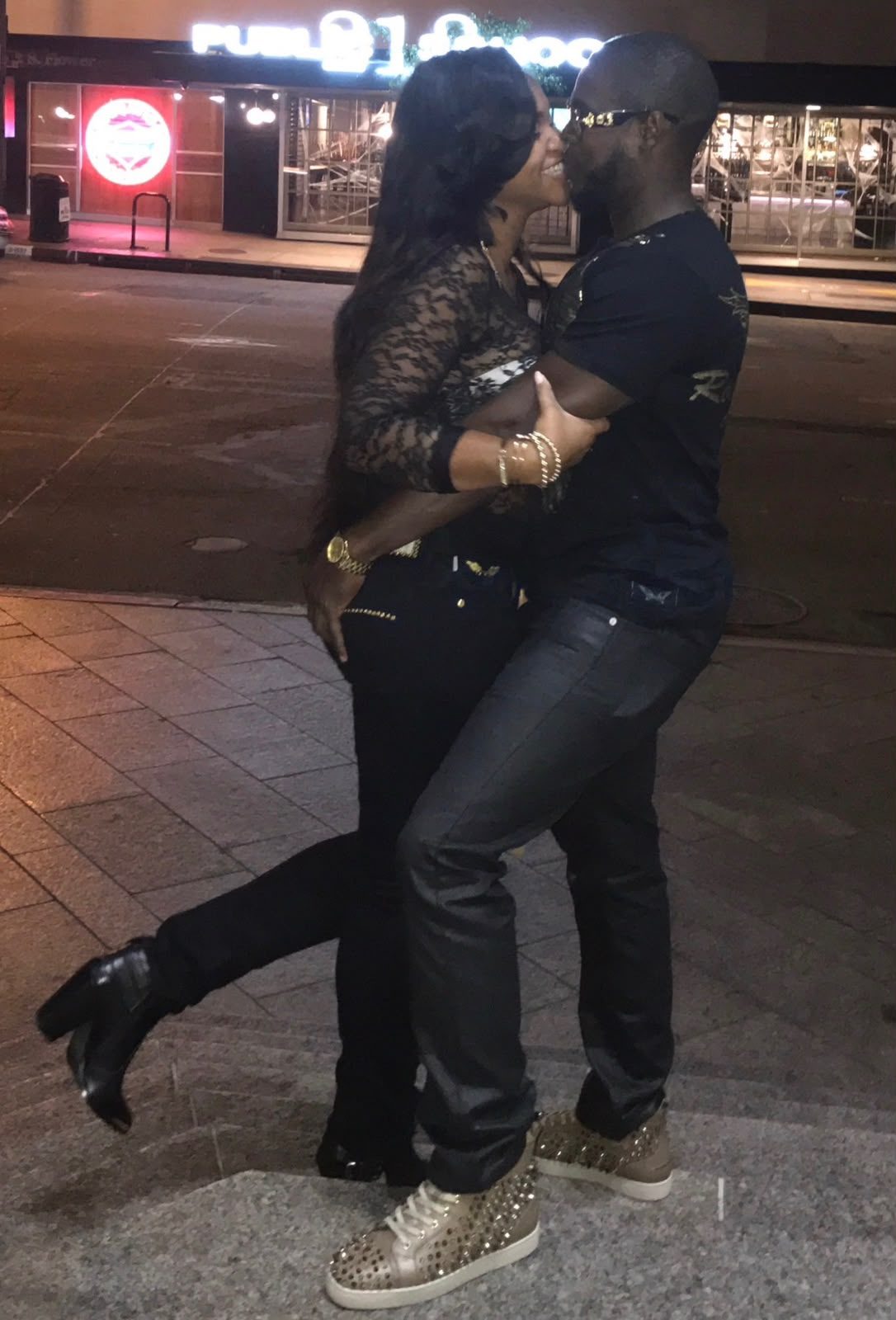 Eugene and Jessica kissing on a city sidewalk at night